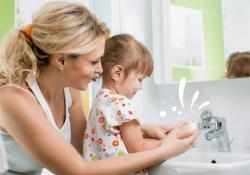 Visuel pour l'article avec une maman qui aide sa fille a se laver les mains.